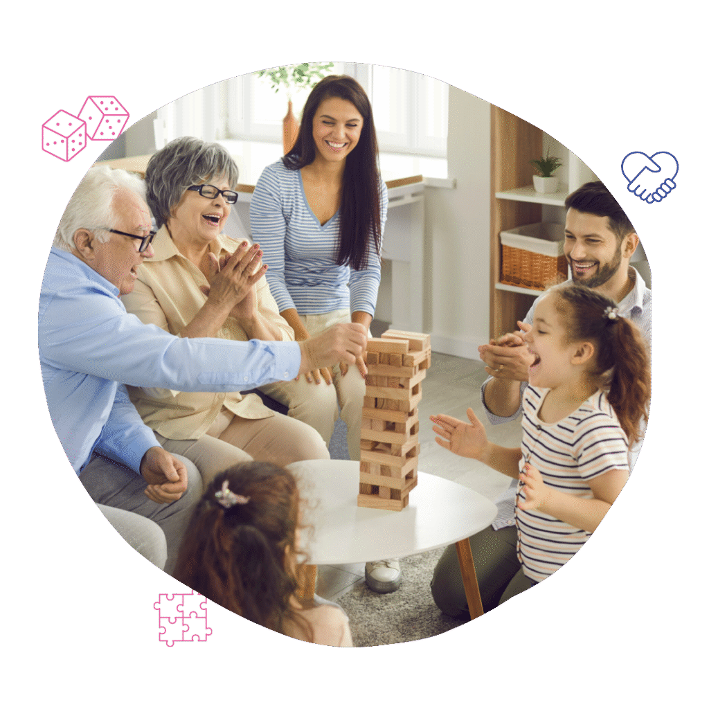 A multi-generational family joyfully plays Jenga, laughing and clapping, embodying Your Best Life Behaviour Support