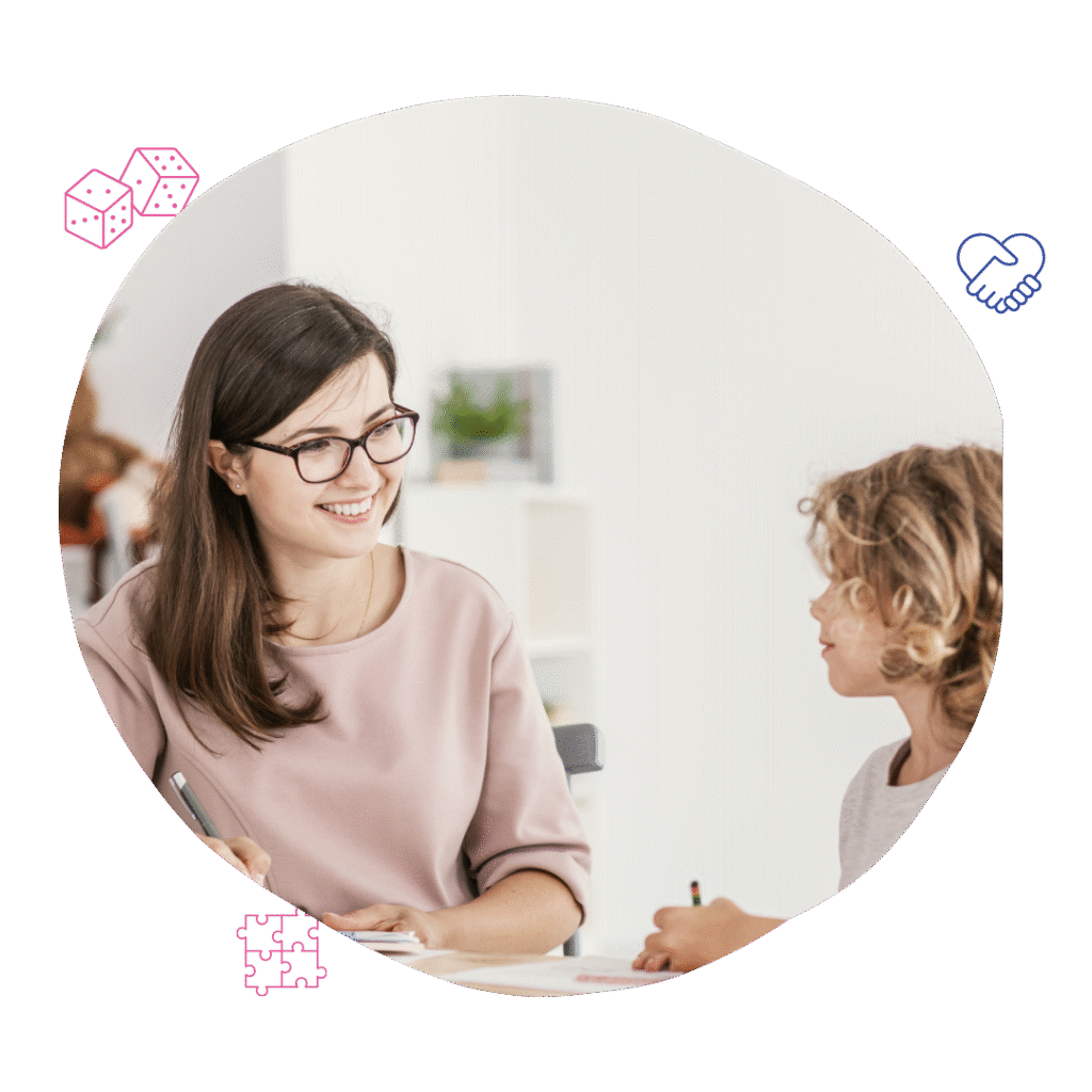 A young child actively listens to a smiling female therapist of Your Best Life Behaviour Support